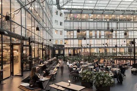 Modernt kontorshotell i Stockholm med öppen atriumgård och coworking-ytor.